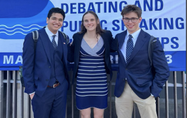 Aaron, Chloe, and Graham stand outside the World Debate Championship in South Africa.
