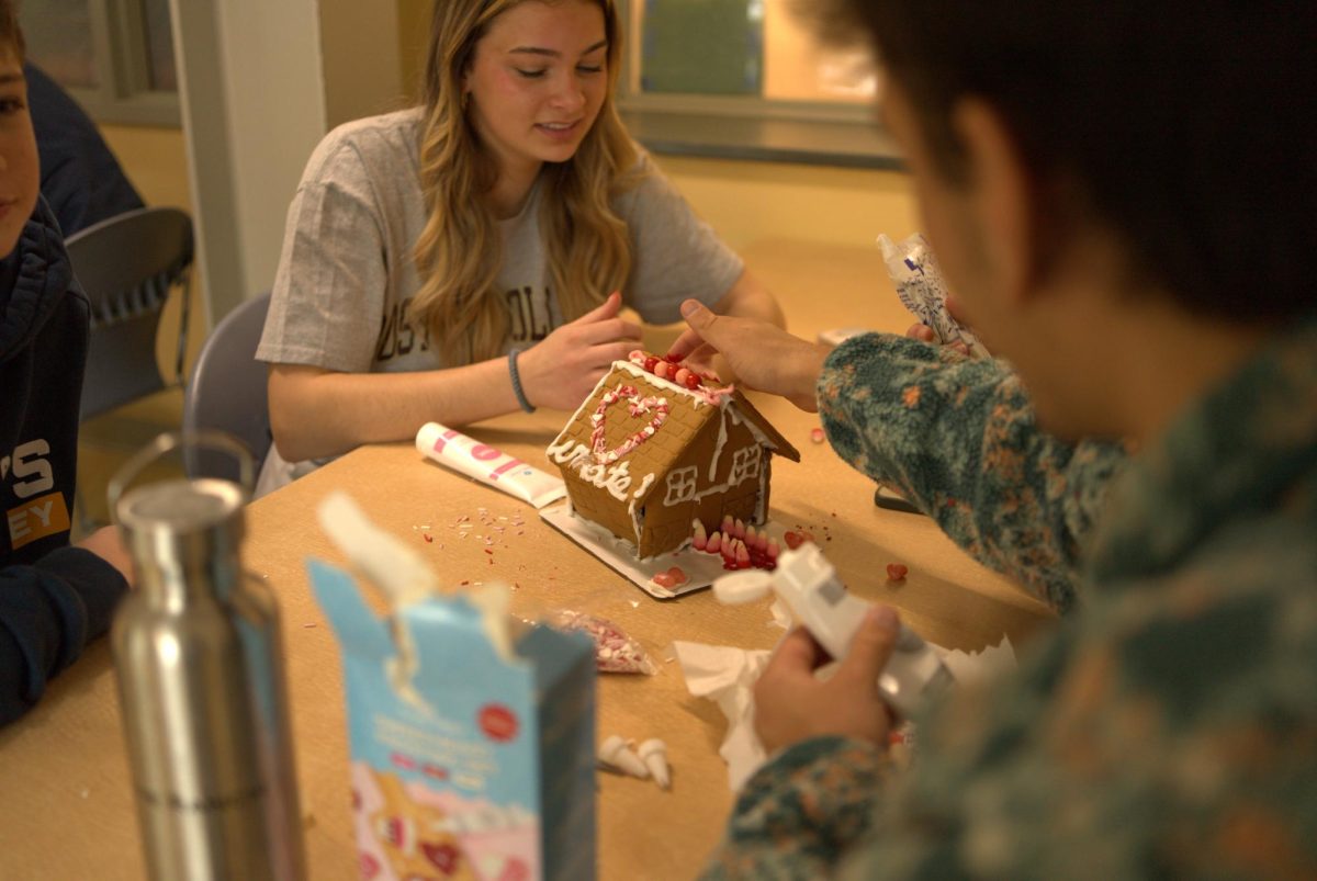 Sarah Baker '28 and Manan Eckton '25 construct a gingerbread house.