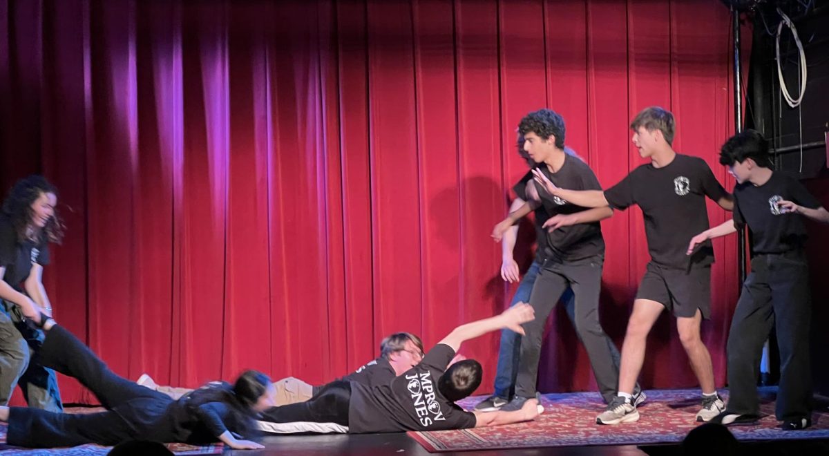 Salar Sekhavat ’26, Justin Hildebrandt and Gordon Miller (both ’27) attempt to ward off Evelyn Marks’ ’29 deadly bad breath performing with Improv Jones at the Regent Theater. (Staff Photo by Yancheng Zhao)