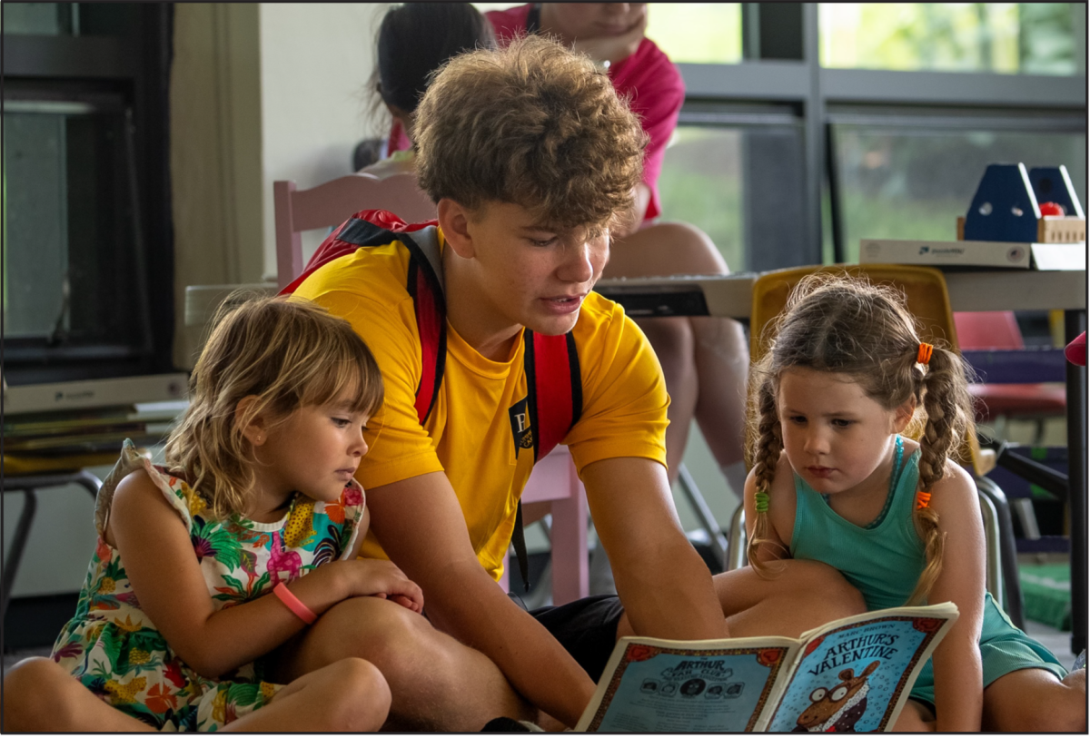 Summer@BB&N counselor Will Gohlmann ’26 reads to his campers. (Photo Courtesy of Quentin Higgins)