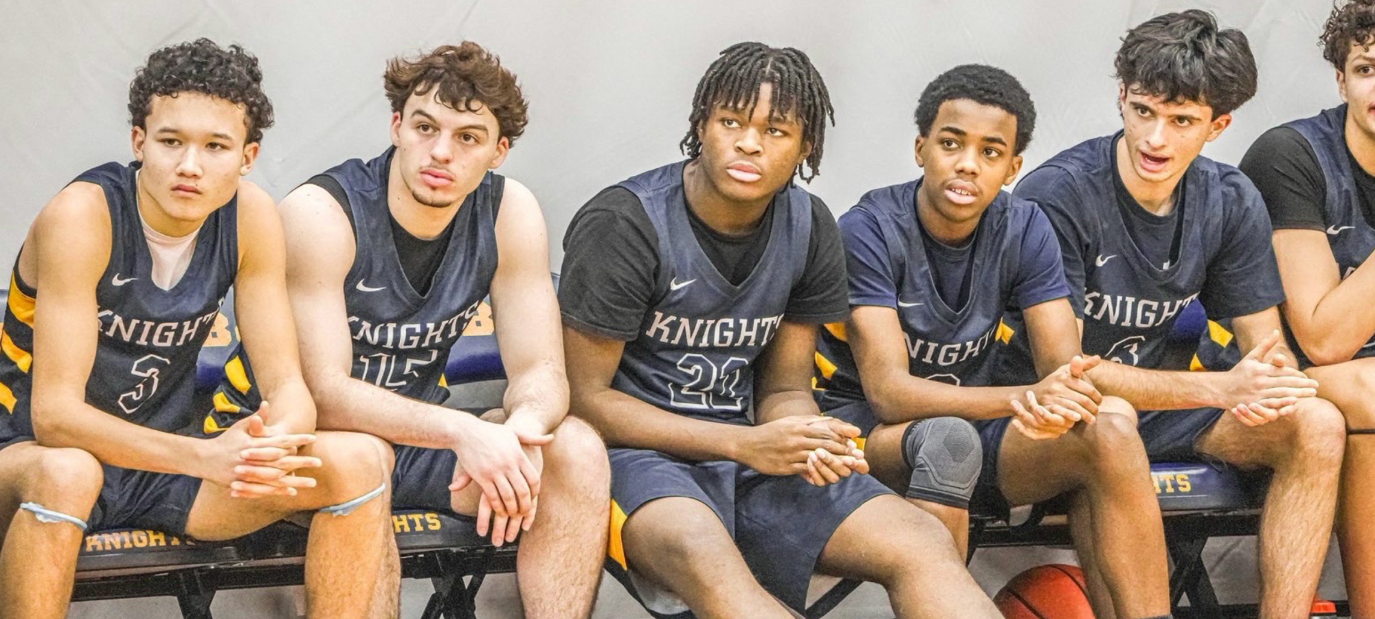 Boys’ Varsity Basketball players wait on the bench, ready to jump into the action. The team played Roxbury Latin on Jan. 23. (Staff Photo by Azariah Zewde)