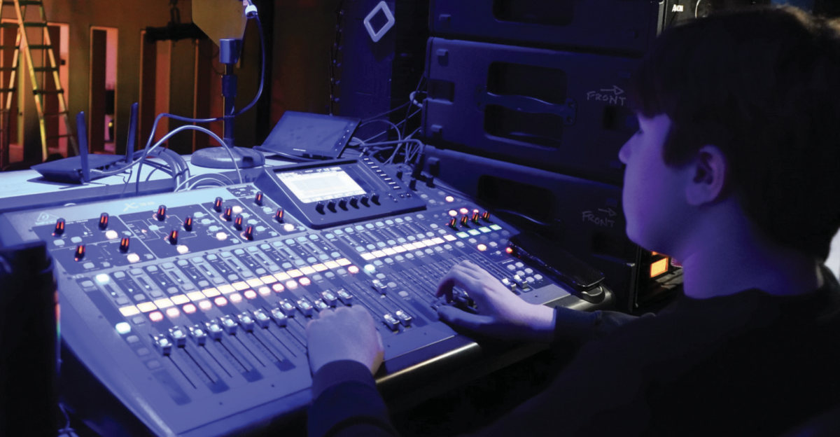 Leo Saul ’28 handles the mics, turning them on and adjusting their volume. (Staff Photo by Olivia Richter)