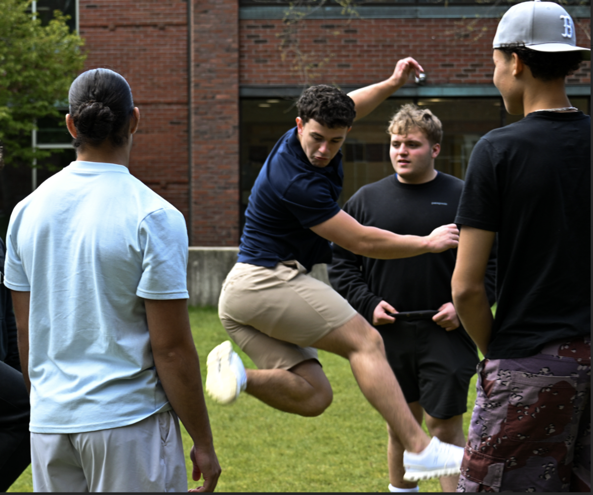 Colin Hoffman ’27 performs a clipper kick in a hacky sack circle.