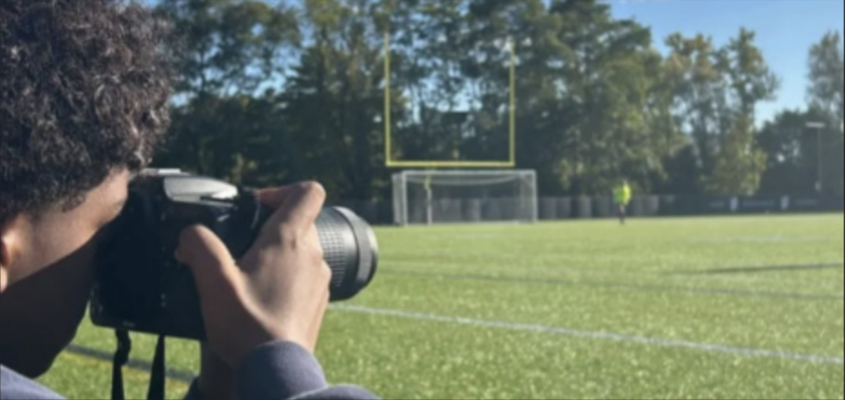 Azariah Zewde ’29 photographs soccer players on the field. He used Instagram posts to build his portfolio and client base.